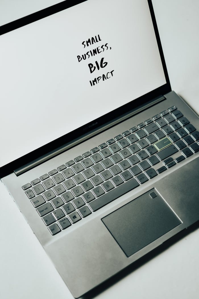 our-journey-03 A laptop screen with the text 'Small Business, Big Impact,' symbolizing modern entrepreneurship.